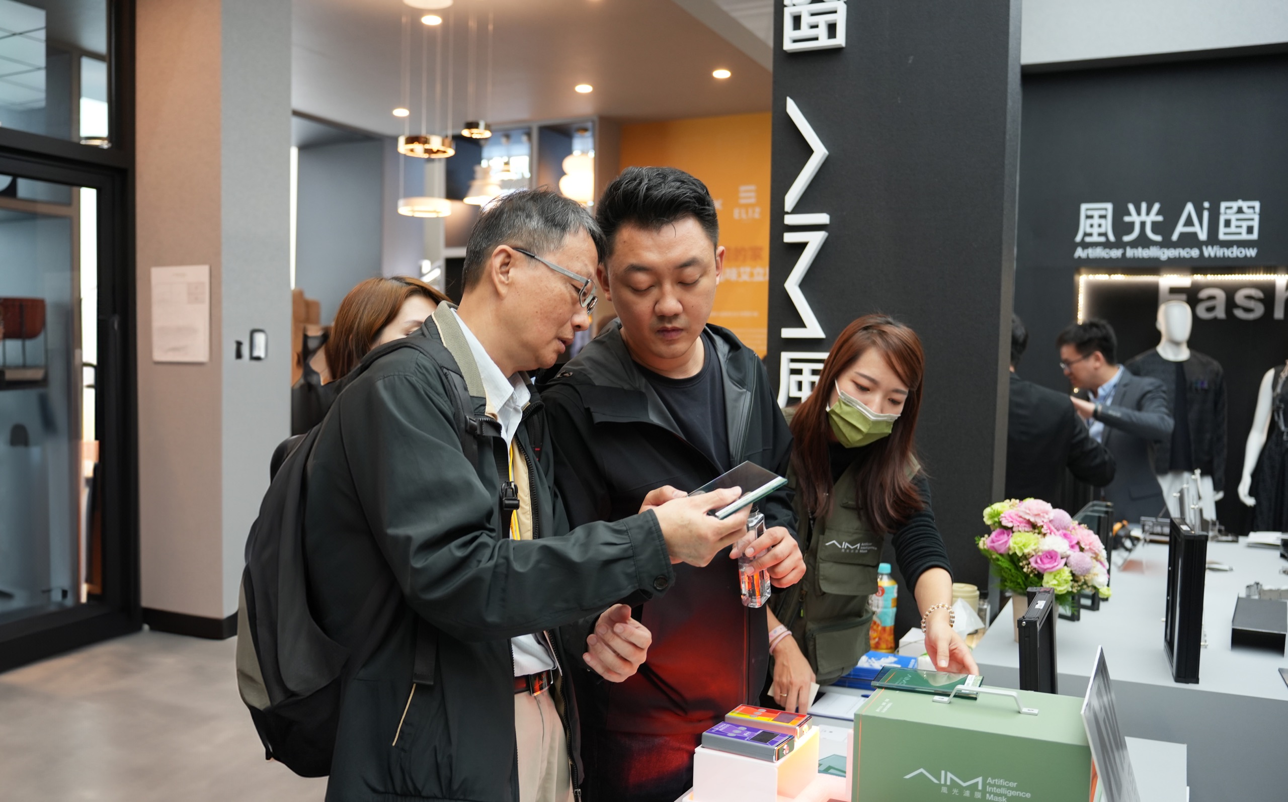 台北建材展風光Ai窗展區:人員向參觀者解說 AIM 風光濾膜產品與樣品