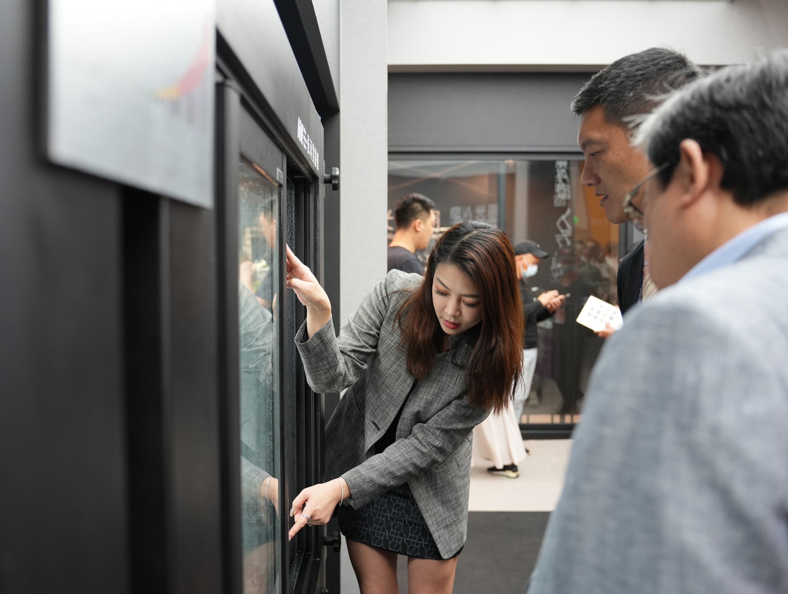 台北建材展現場:人員實地示範黑色鋁框窗的開啟操作與五金結構