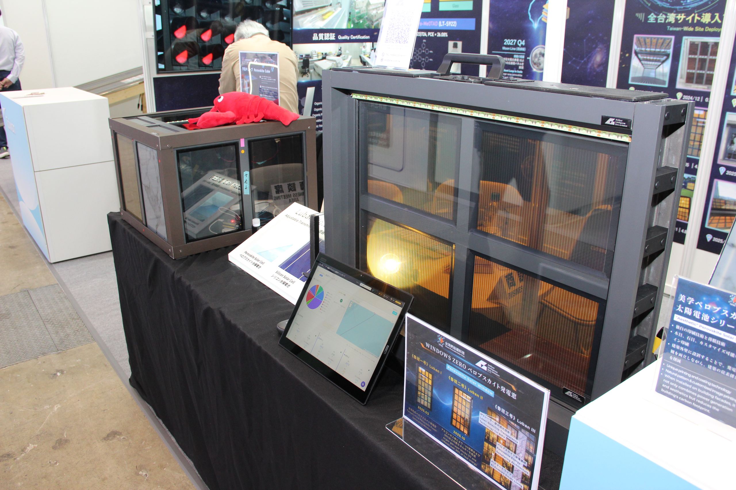 日本智慧能源週風光淨零展位,展出 WINDOWS ZERO 鈣鈦礦發電窗實品與 Perovskite Cube,說明板列出魯班一號至三號的產品演進